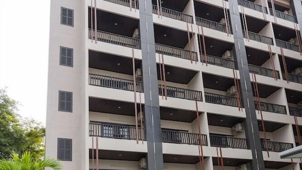 A multi-story building with balconies, a swimming pool, and surrounding greenery. - Essential Pattaya (Pattaya)