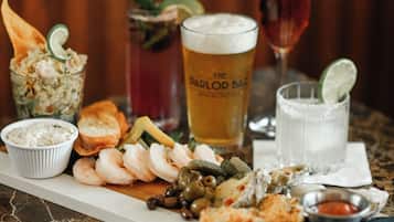 A table with various food items and drinks, including shrimp, bread, and a glass of beer.