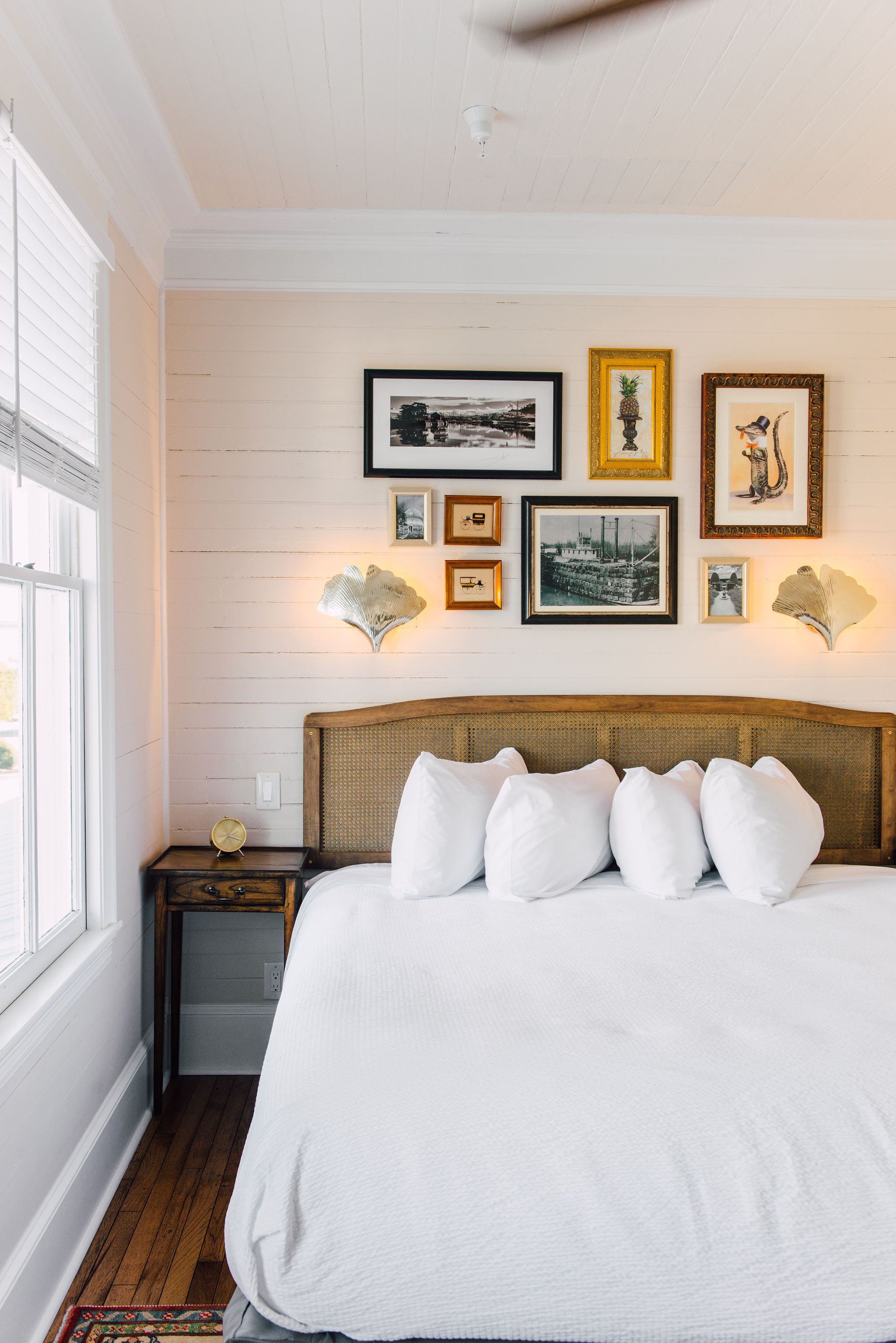 Een slaapkamer met een groot bed, een nachtkastje en kunst aan de muur.