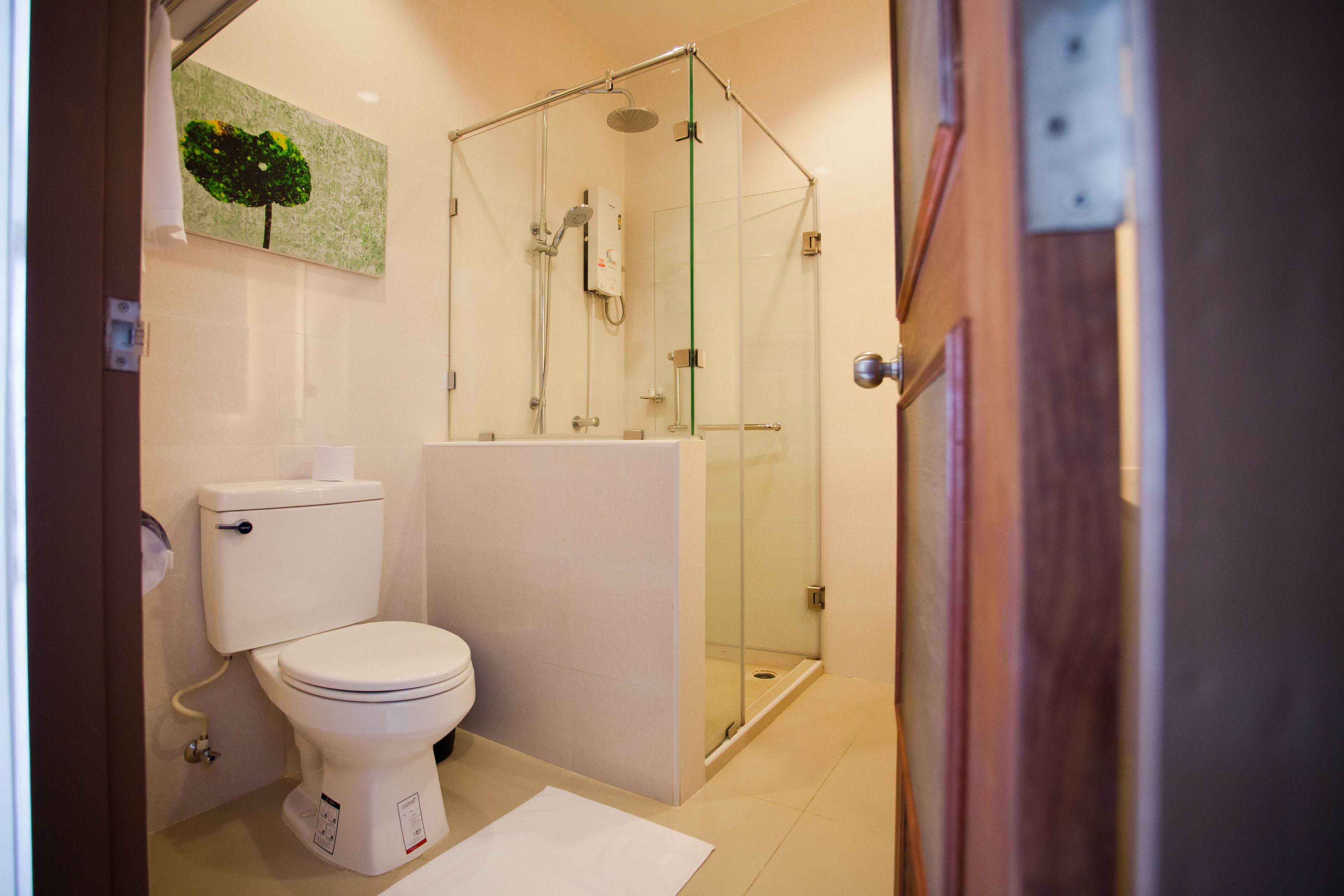 Un baño moderno con inodoro, lavamanos y ducha envuelta en vidrio.