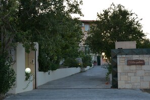 A villa with a stone entrance, a sign reading "Villa galini," and a pathway leading to the building. - Villa Galini (Hersonissos)