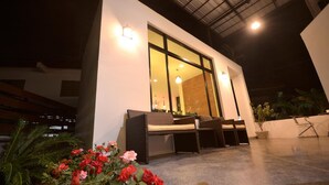 An outdoor seating area with wicker furniture and a potted plant. - Good Home Udonthani (Udon Thani)