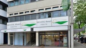 Exterior del hotel INVITE en Fulda, con una fachada moderna, amplias ventanas y una entrada acogedora.