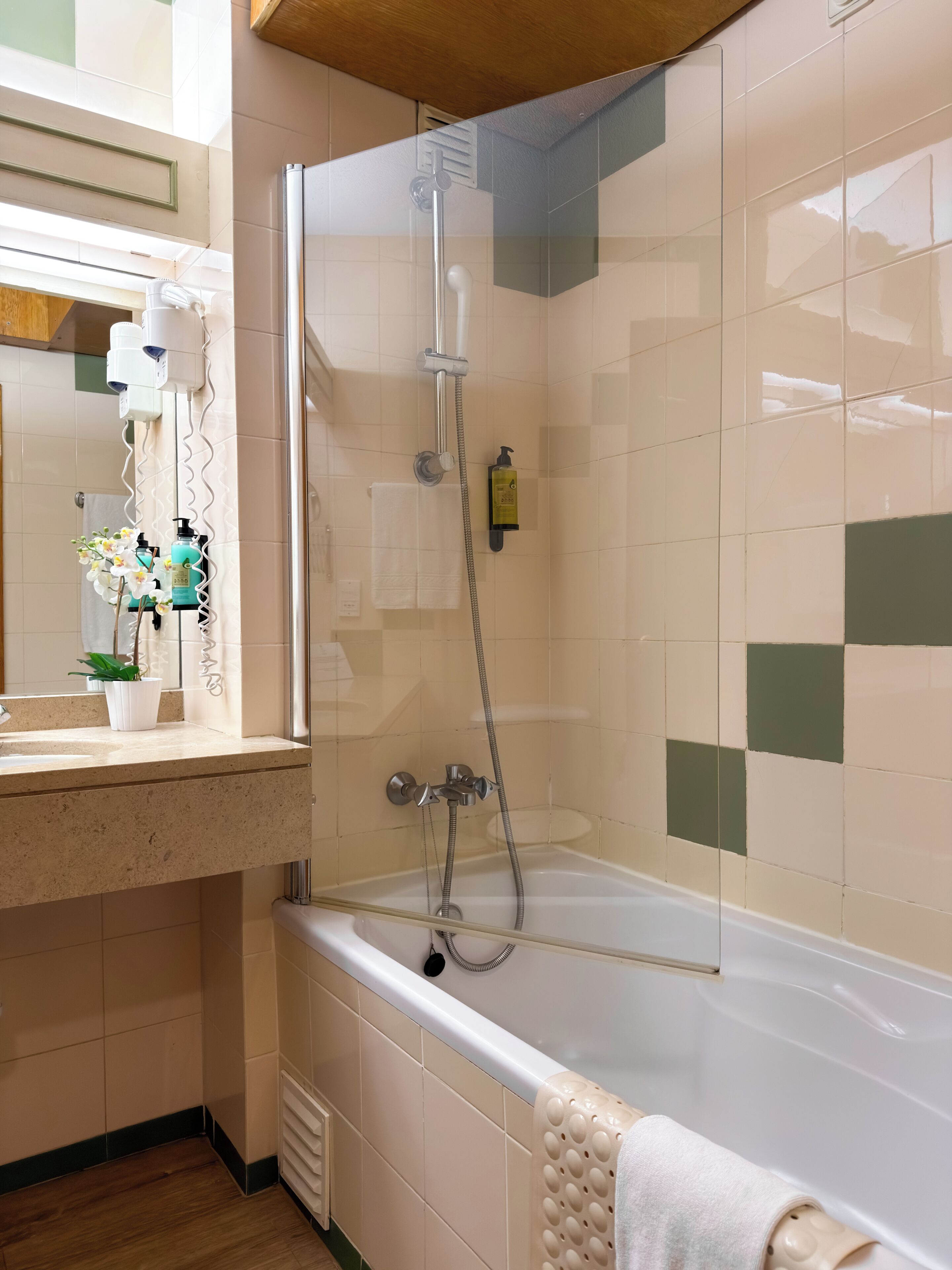 Ein Badezimmer mit Dusche, Badewanne, Waschbecken und Spiegel.