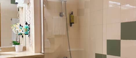 Ein Badezimmer mit Dusche, Badewanne, Waschbecken und Spiegel.
