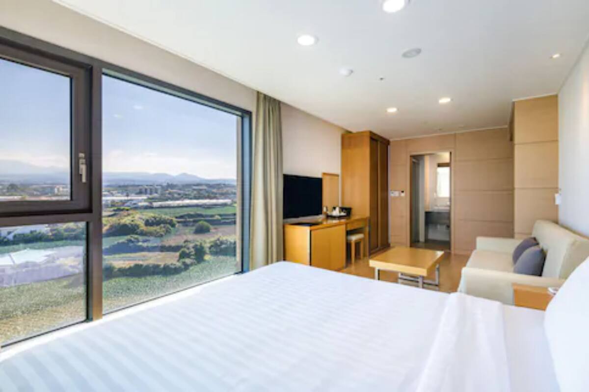 Une chambre d’hôtel moderne équipée d’un grand lit, d’un bureau, d’un canapé et d’une télévision.