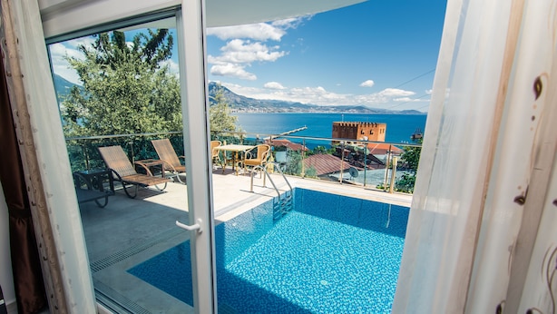 A balcony with a pool, overlooking a scenic view of the sea and mountains. - Lemon Villa Hotel - Adult Only (Alanya)