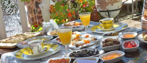 Una mesa preparada con diversos alimentos para el desayuno, como frutas, pan y bebidas.