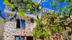 A stone building with a wooden staircase leading to a balcony. - Lemon Villa Hotel - Adult Only (Alanya)
