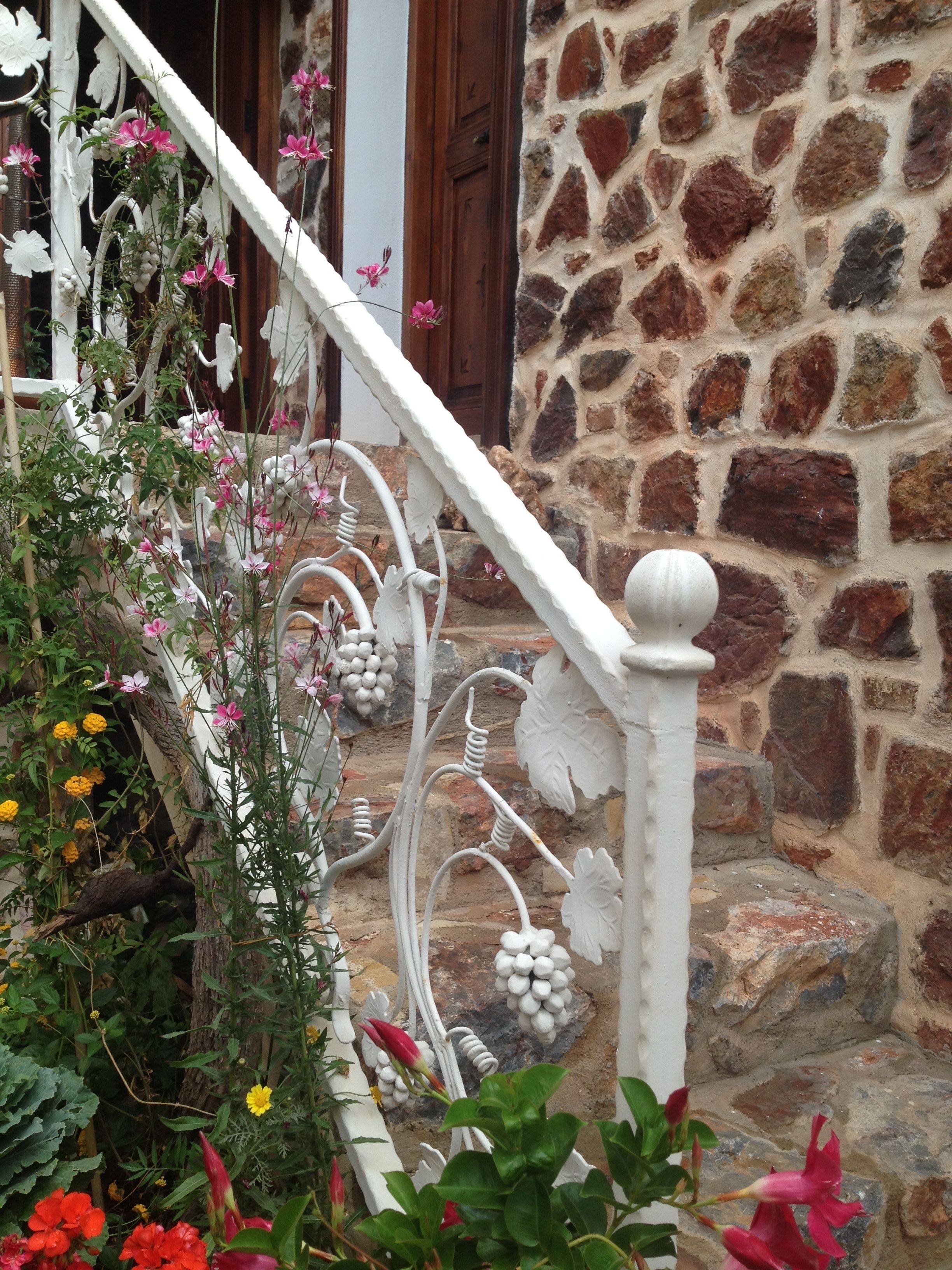 A stone building with a white staircase and decorative metal railings.