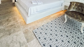 A modern bedroom with a large bed, a tufted sofa, and a patterned rug. - Lemon Villa Hotel - Adult Only (Alanya)