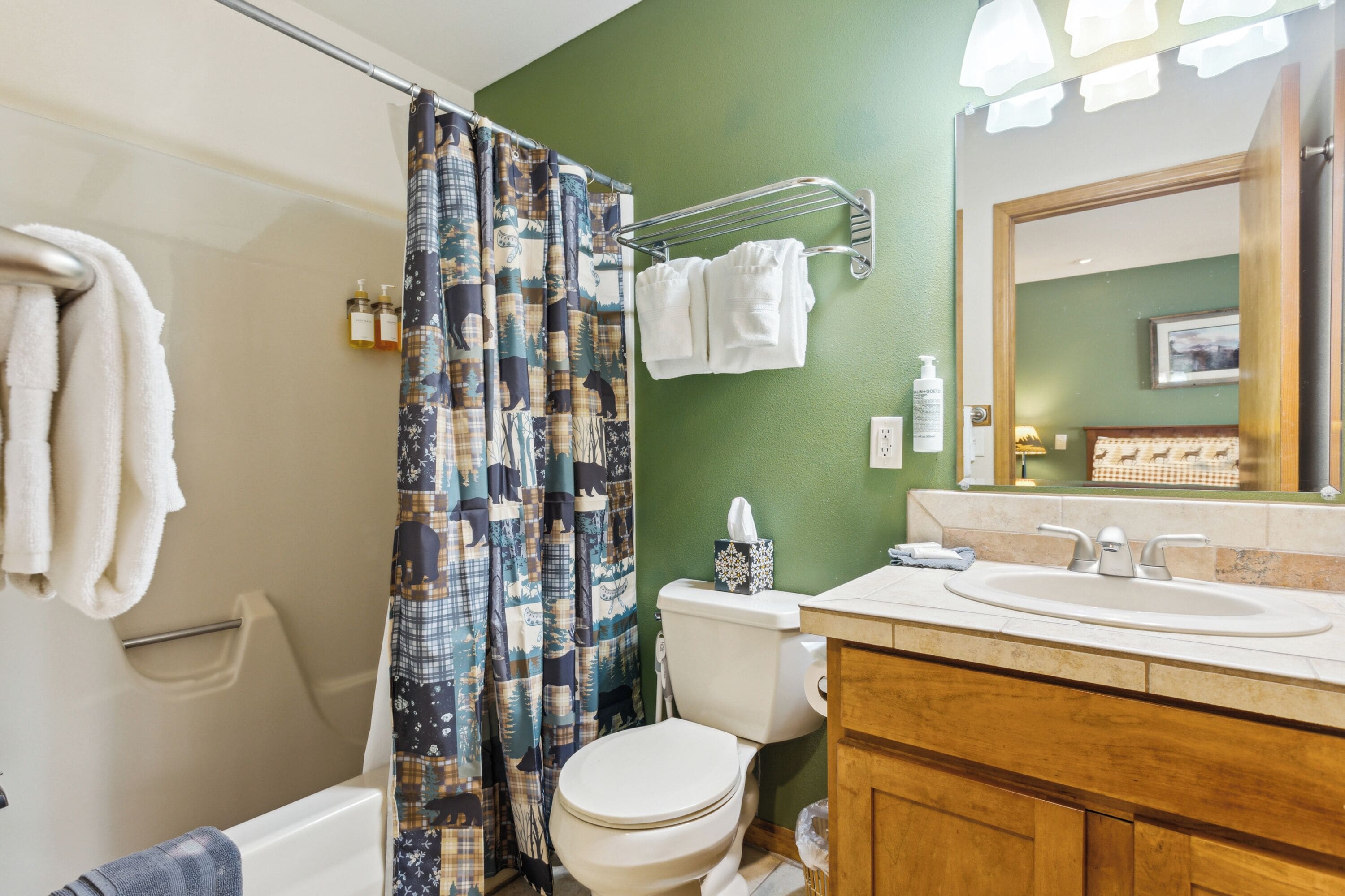 A bathroom with a toilet, sink, and shower curtain.