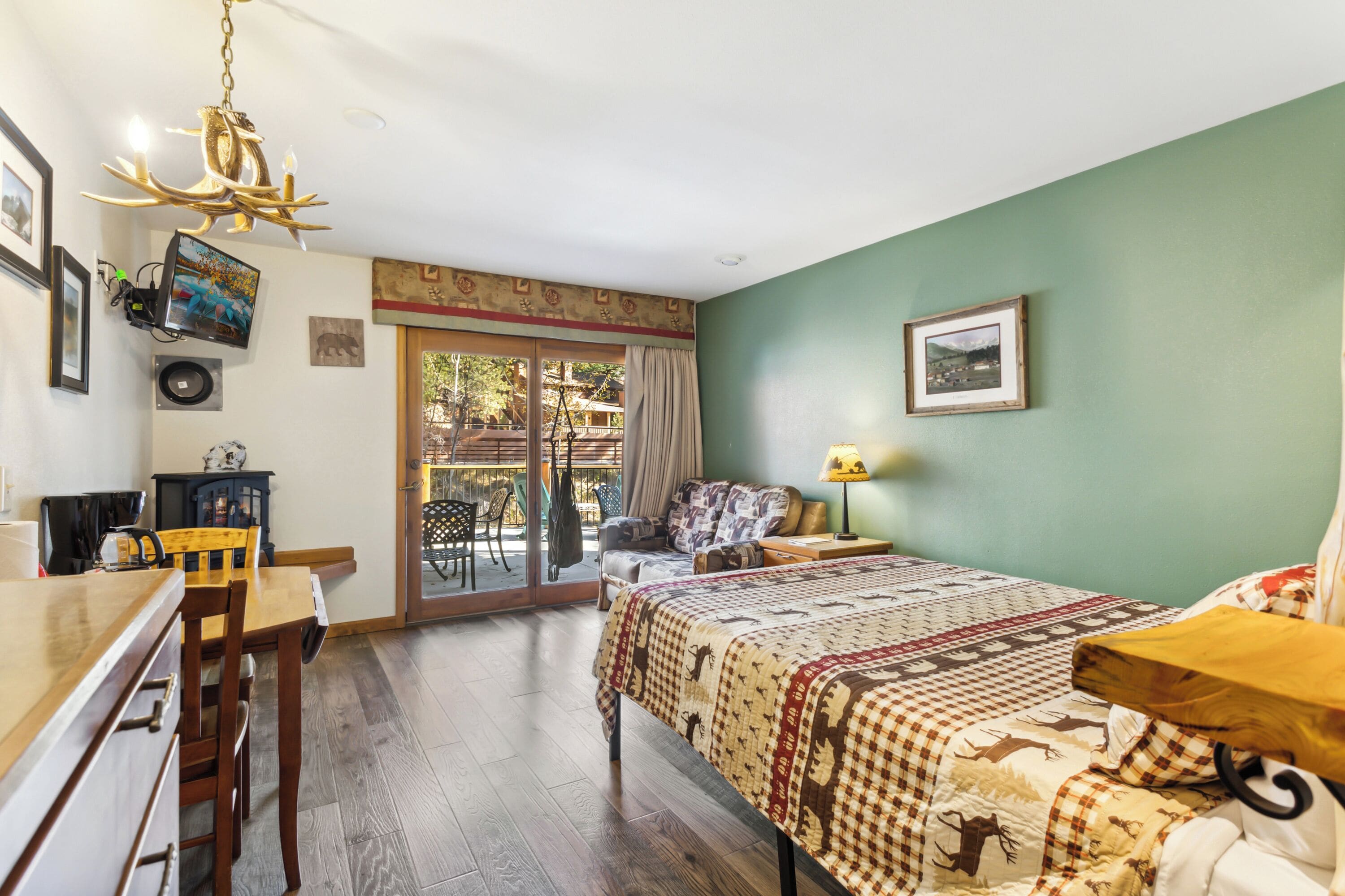 Een slaapkamer met een bed, een bureau, een stoel, een lamp en een televisie aan de muur.