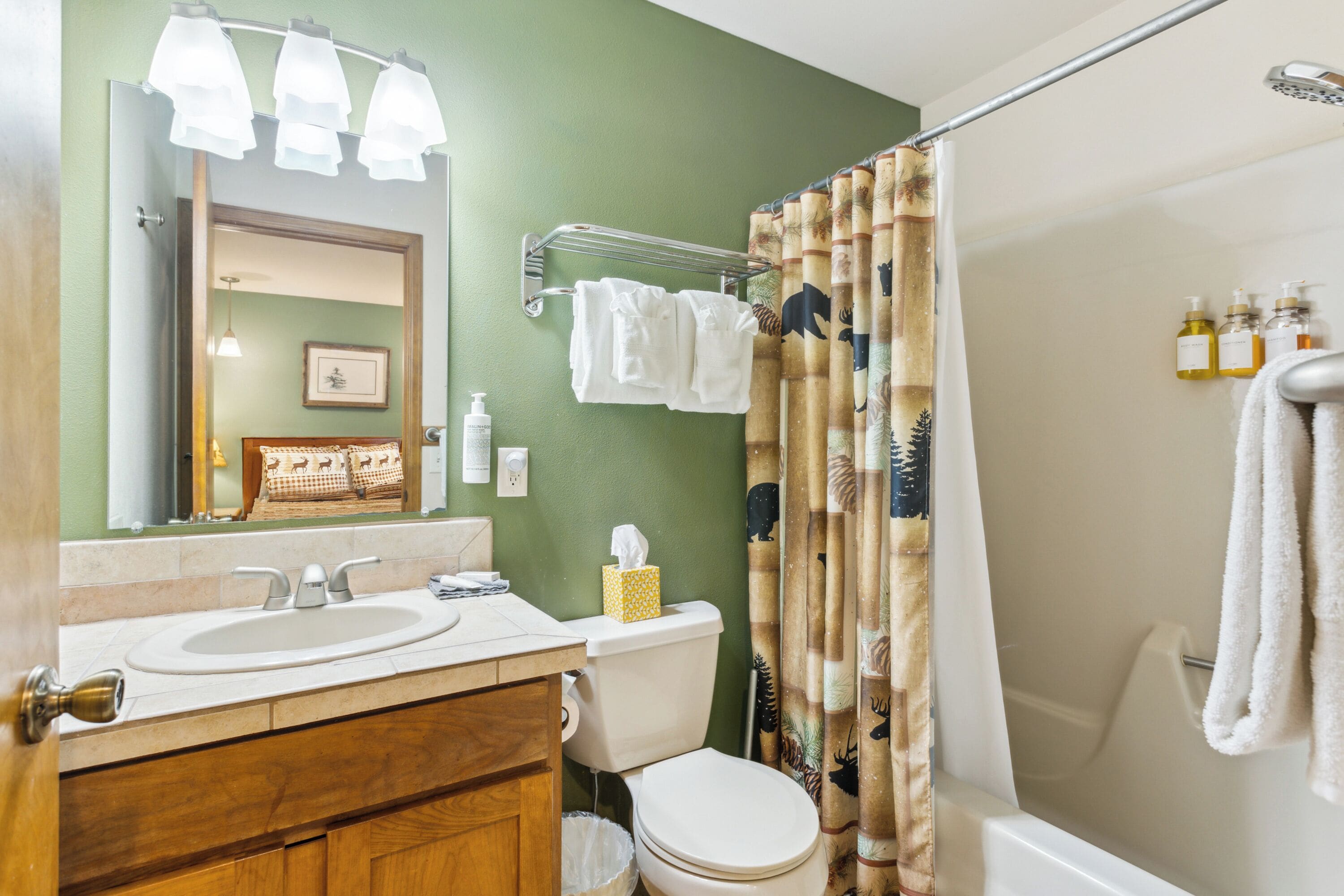 A bathroom with a sink, toilet, and shower curtain.