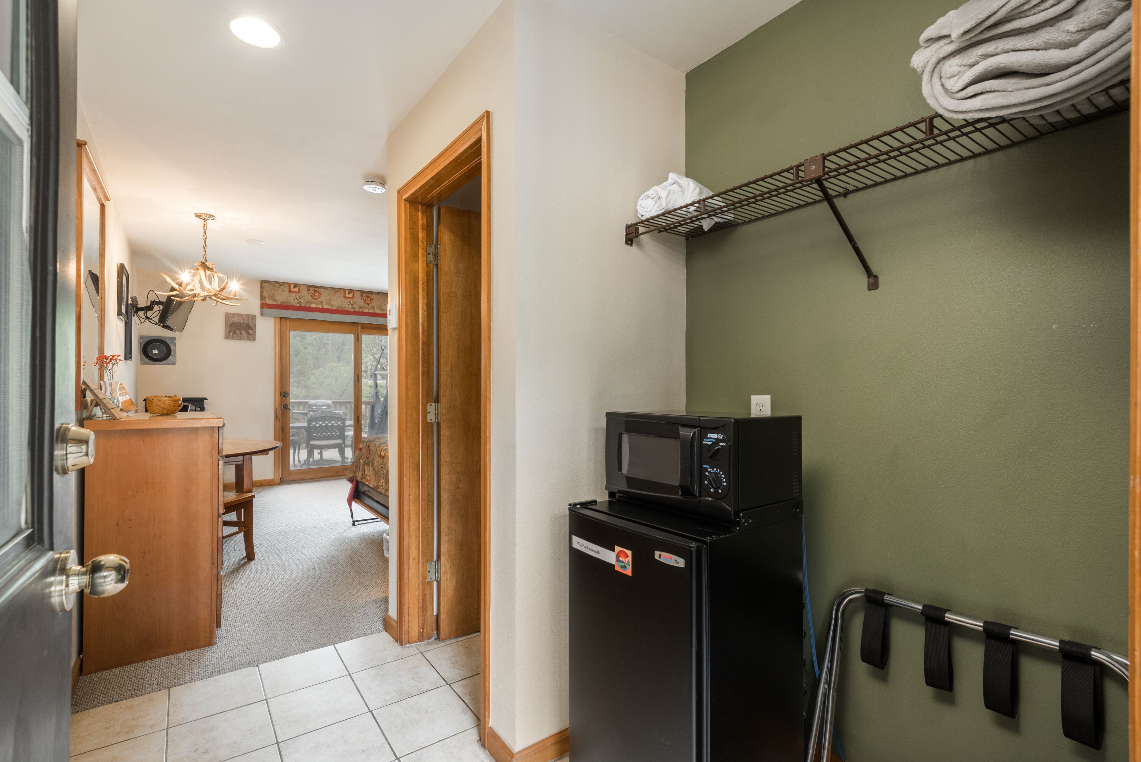 Una cocina compacta con microondas, refrigerador y un pequeño desayunador.
