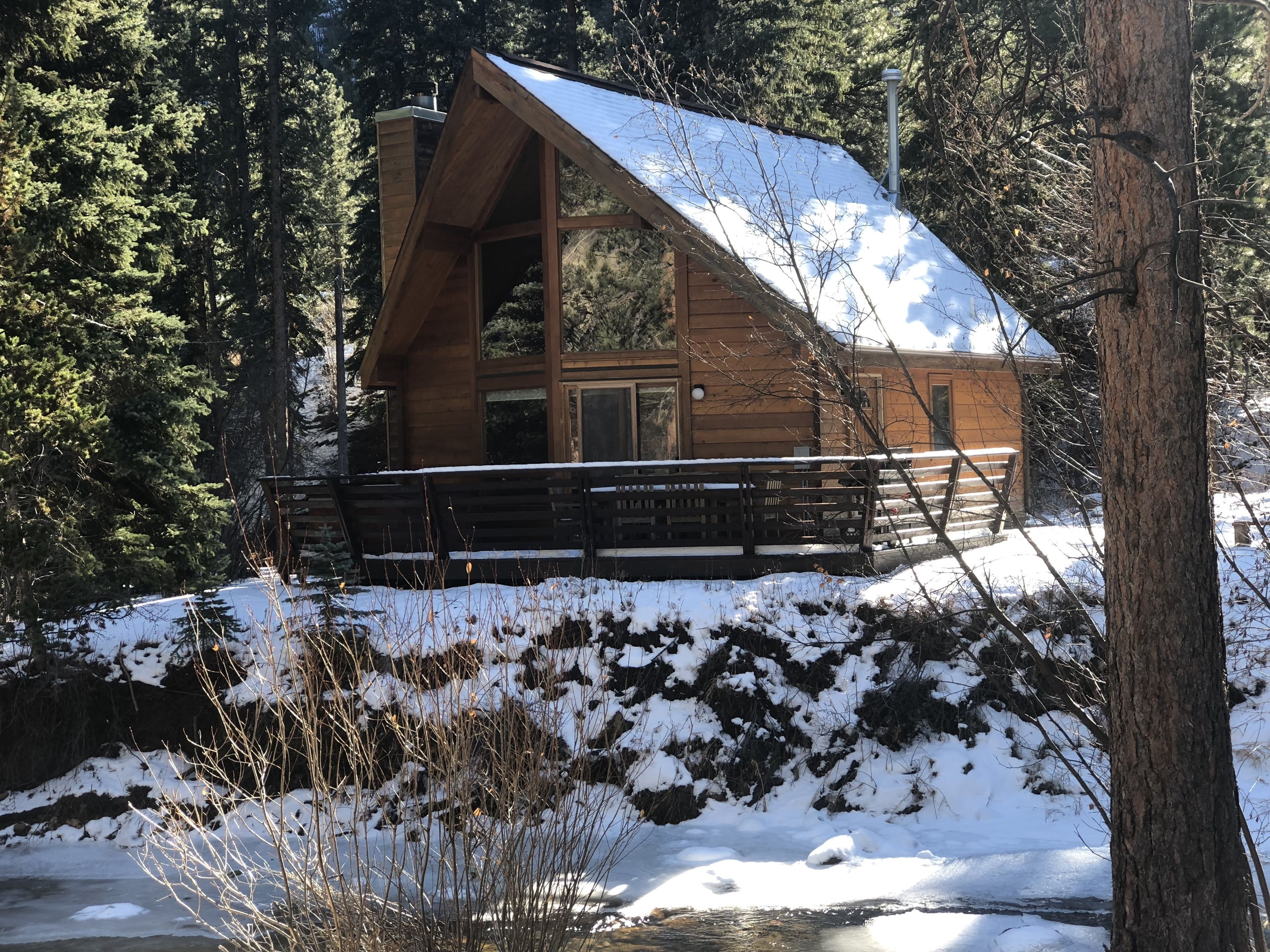 Eine Holzhütte mit geneigtem Dach und einer Veranda.