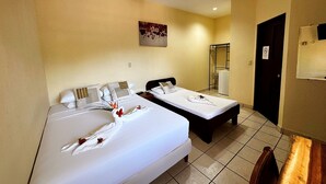 A hotel room with two beds, a ceiling fan, a painting on the wall, and a door with a sign. - Hotel Nany (Cabo Velas)