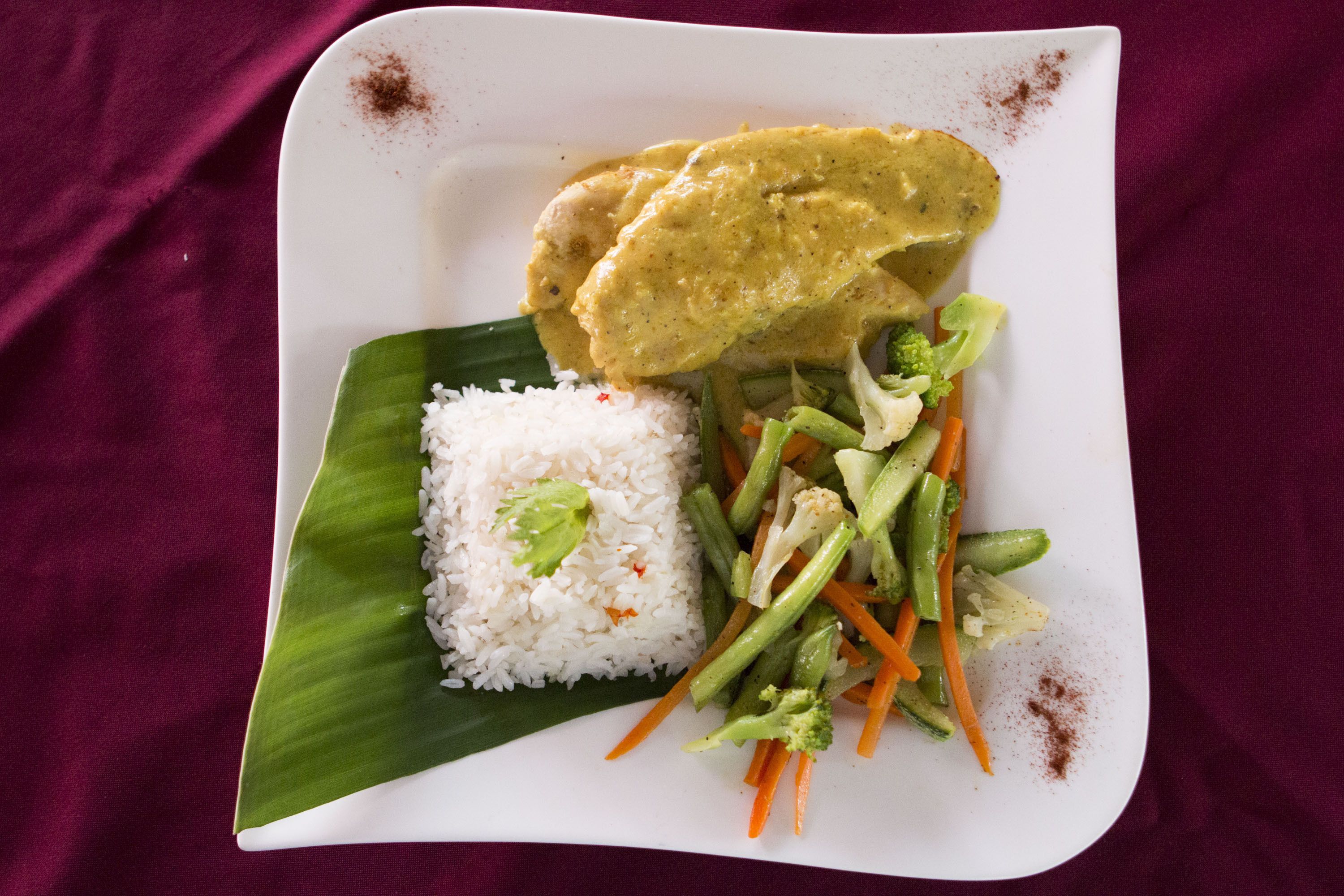 A plate of food with rice, vegetables, and a curry dish.