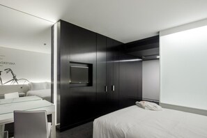 Een moderne hotelkamer met een bed, een bureau en een kledingkast.