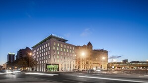 Un hôtel à plusieurs étages, de style architectural classique, qui se distingue par son entrée imposante et une grande enseigne.