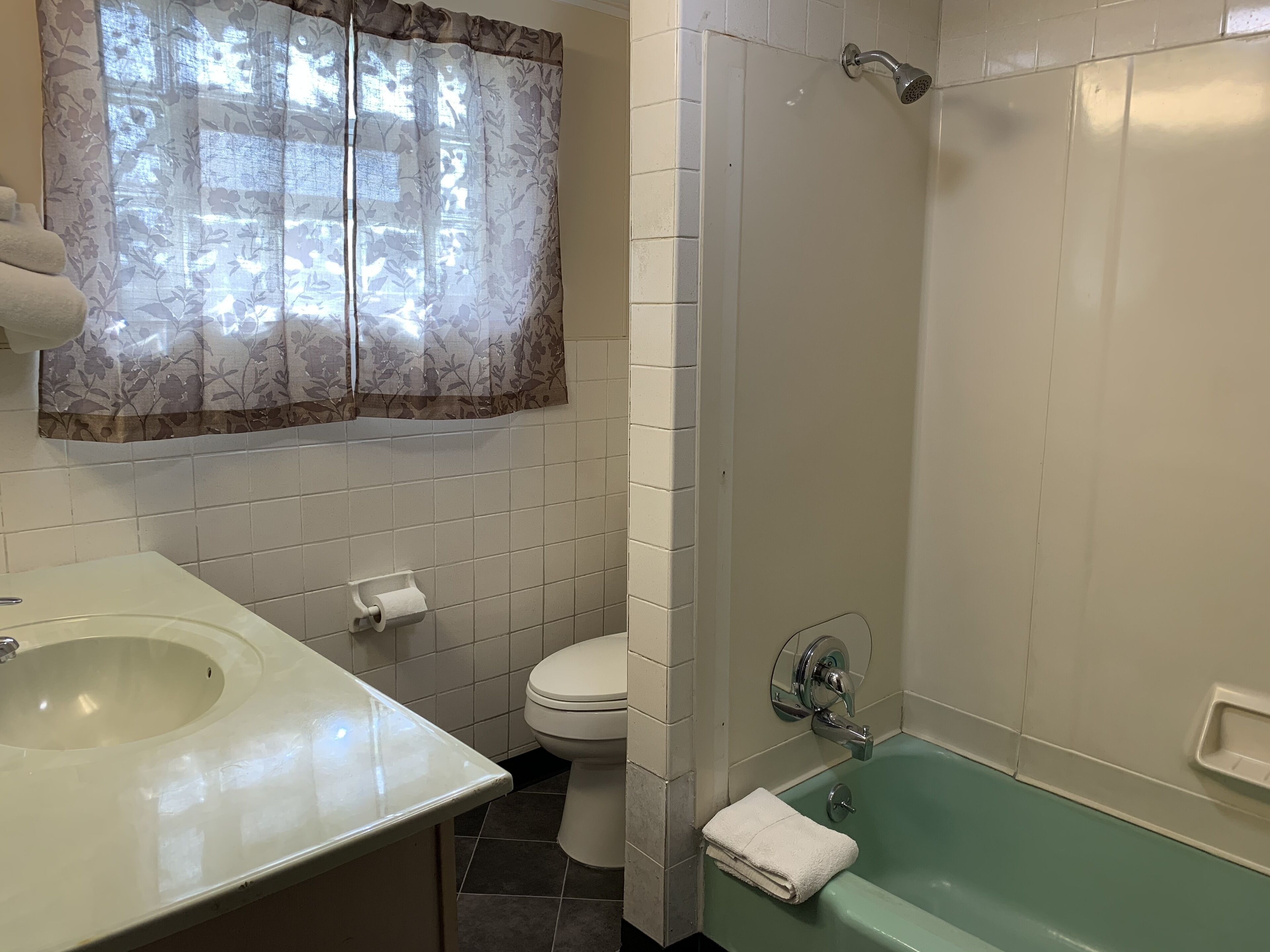 A bathroom with a sink, toilet, and shower.
