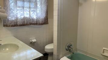 A bathroom with a sink, toilet, and shower.