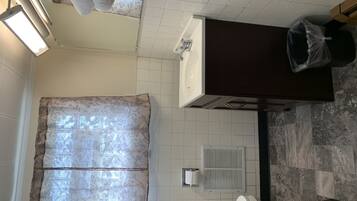 A bathroom with a bathtub, a toilet, a sink, a shower curtain, and a towel rack.