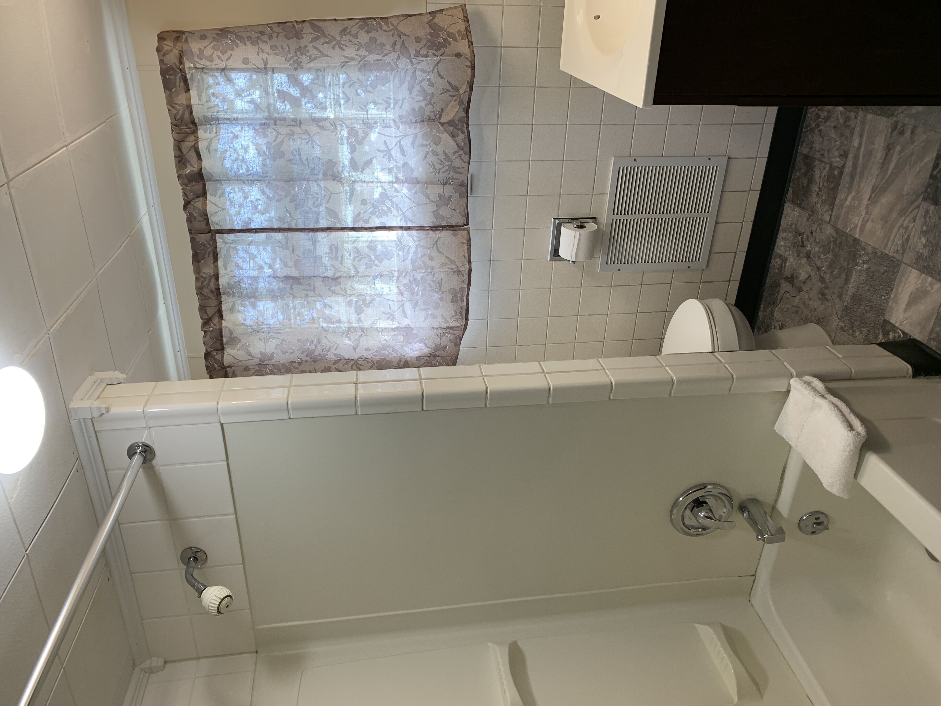 A bathroom with a bathtub, toilet, and shower.