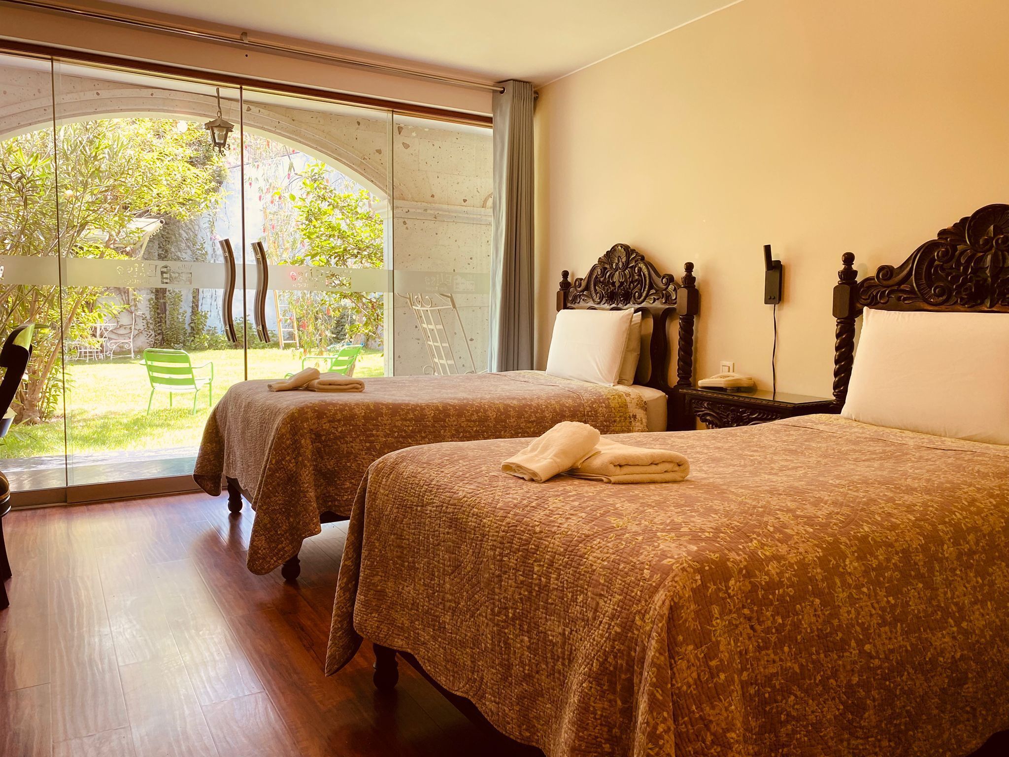 Une chambre d’hôtel avec deux lits, une grande fenêtre et une vue sur l’extérieur.