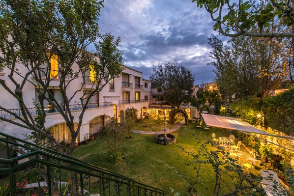 Un patio con una fuente, asientos al aire libre y una escalera.