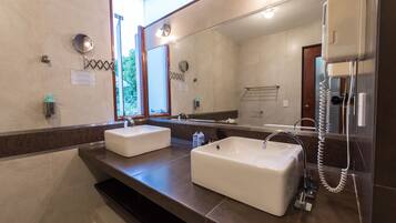 A bathroom with two sinks, a large mirror, and a hairdryer.