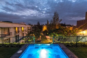 Una piscina con vistas a un complejo de edificios y zonas verdes.