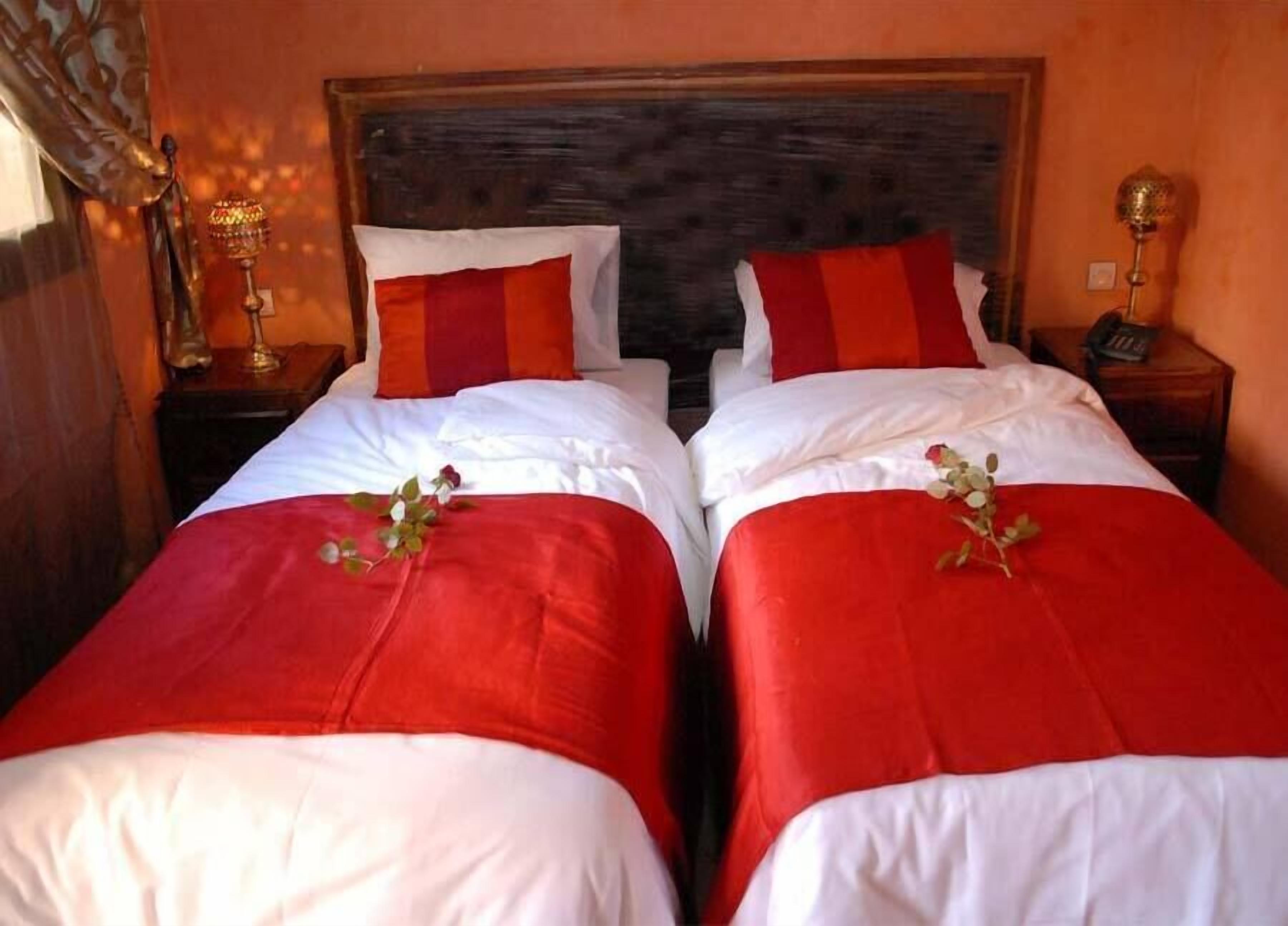 A double bed with red and white bedding and a wooden headboard.