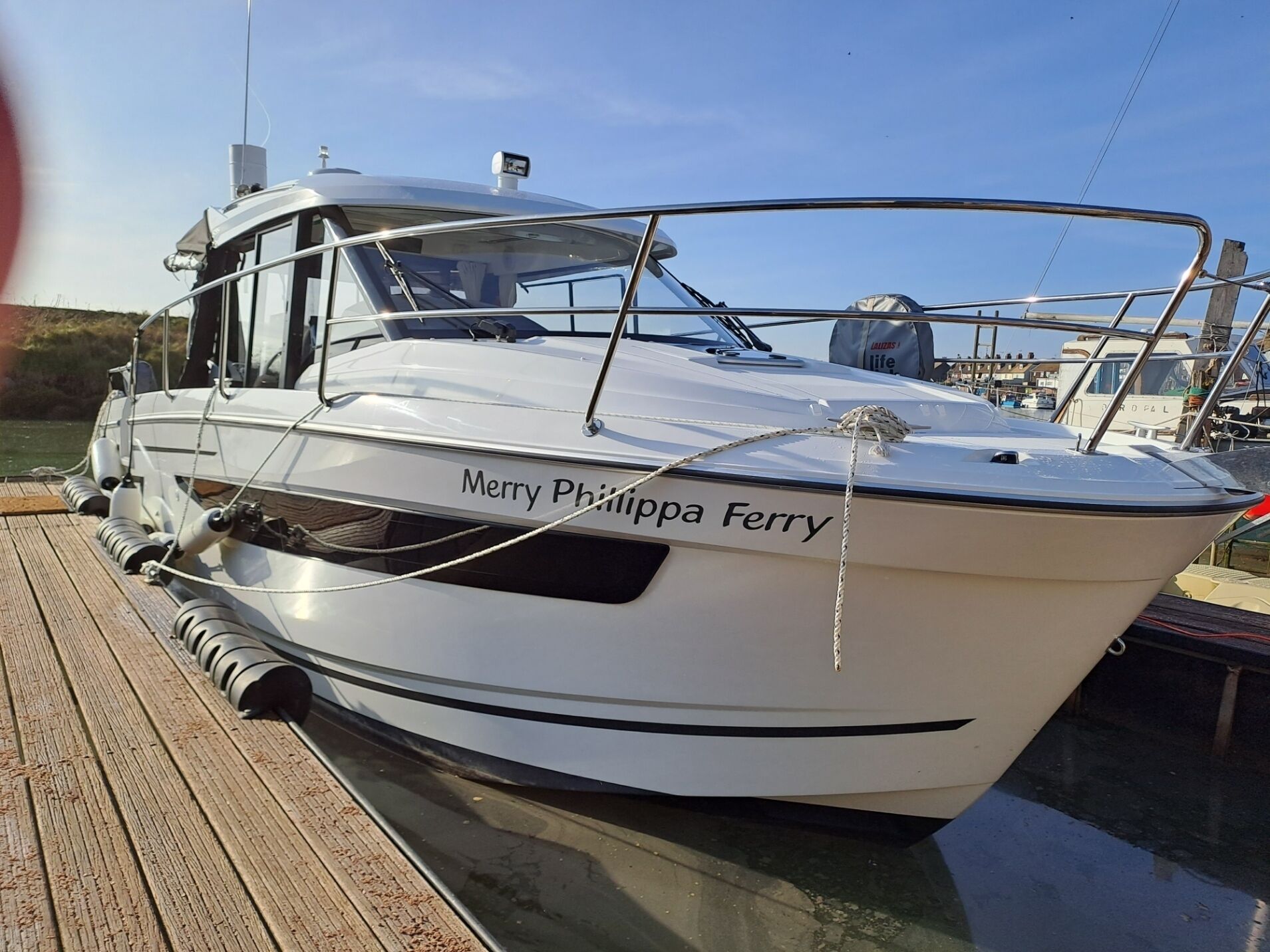 A white boat named "Merry Philippa Ferry" docked at a marina.