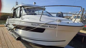 Ein weißes Boot namens "Merry Philippa Ferry" liegt in einer Marina festgemacht.