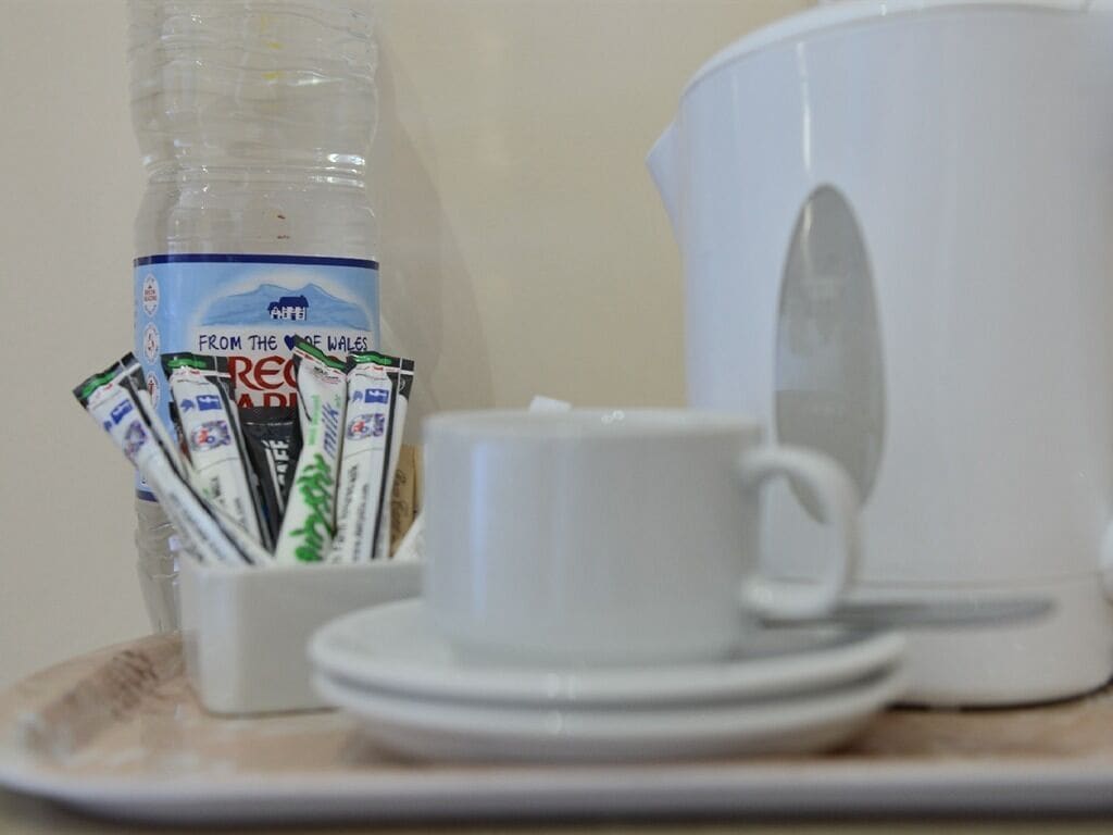 Ein Tisch mit einer Milchflasche, einer Tasse und einer Kanne.