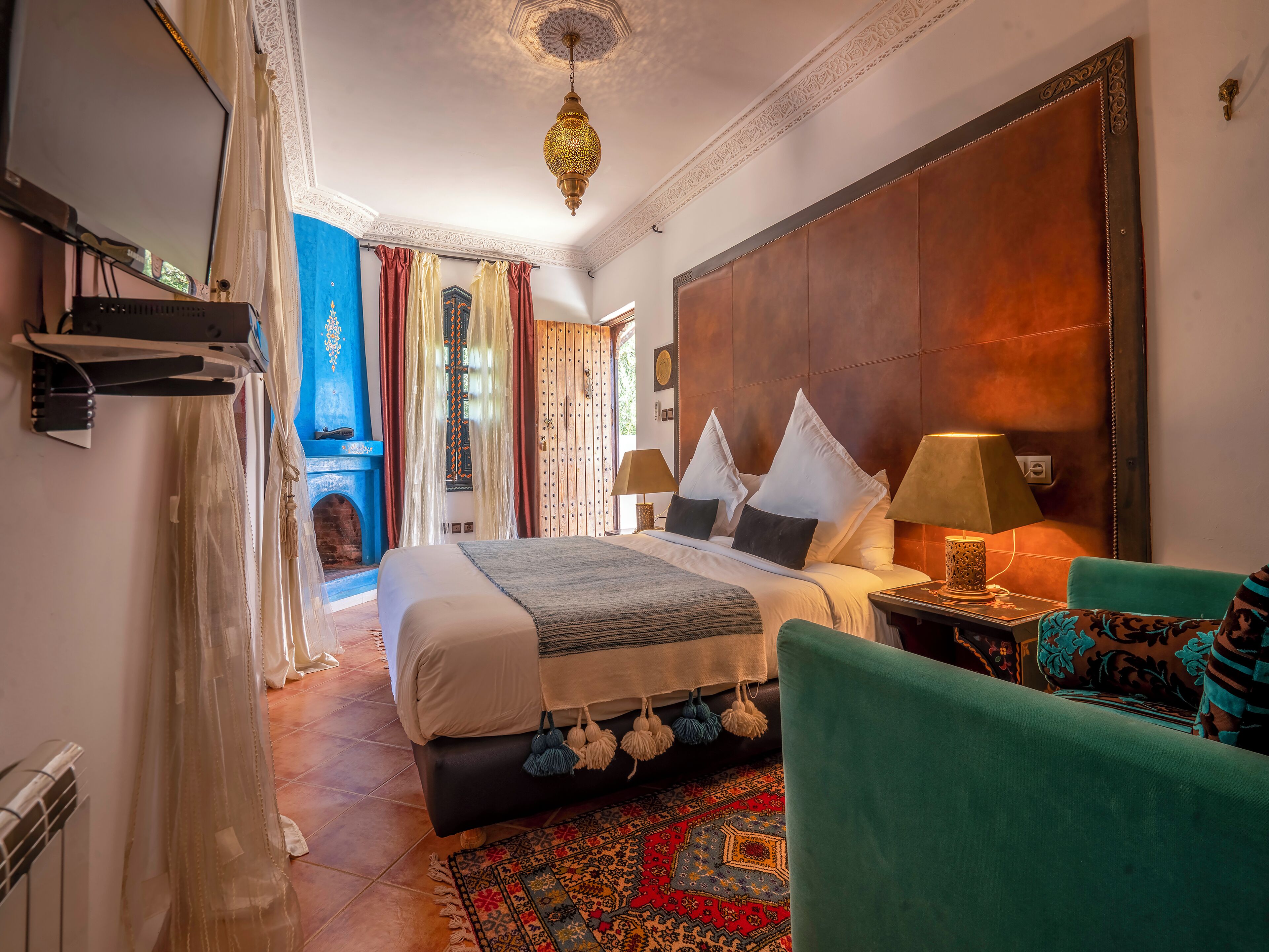 Un dormitorio amplio con una cama grande, un techo decorativo y vistas a un patio.