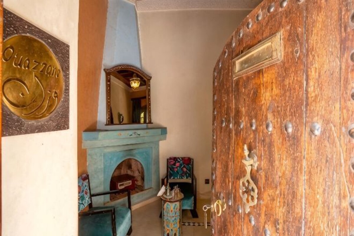 Una habitación con puerta de madera, pared azul y chimenea.