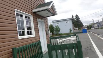 A residential house with a front porch, a mailbox, and a street view.