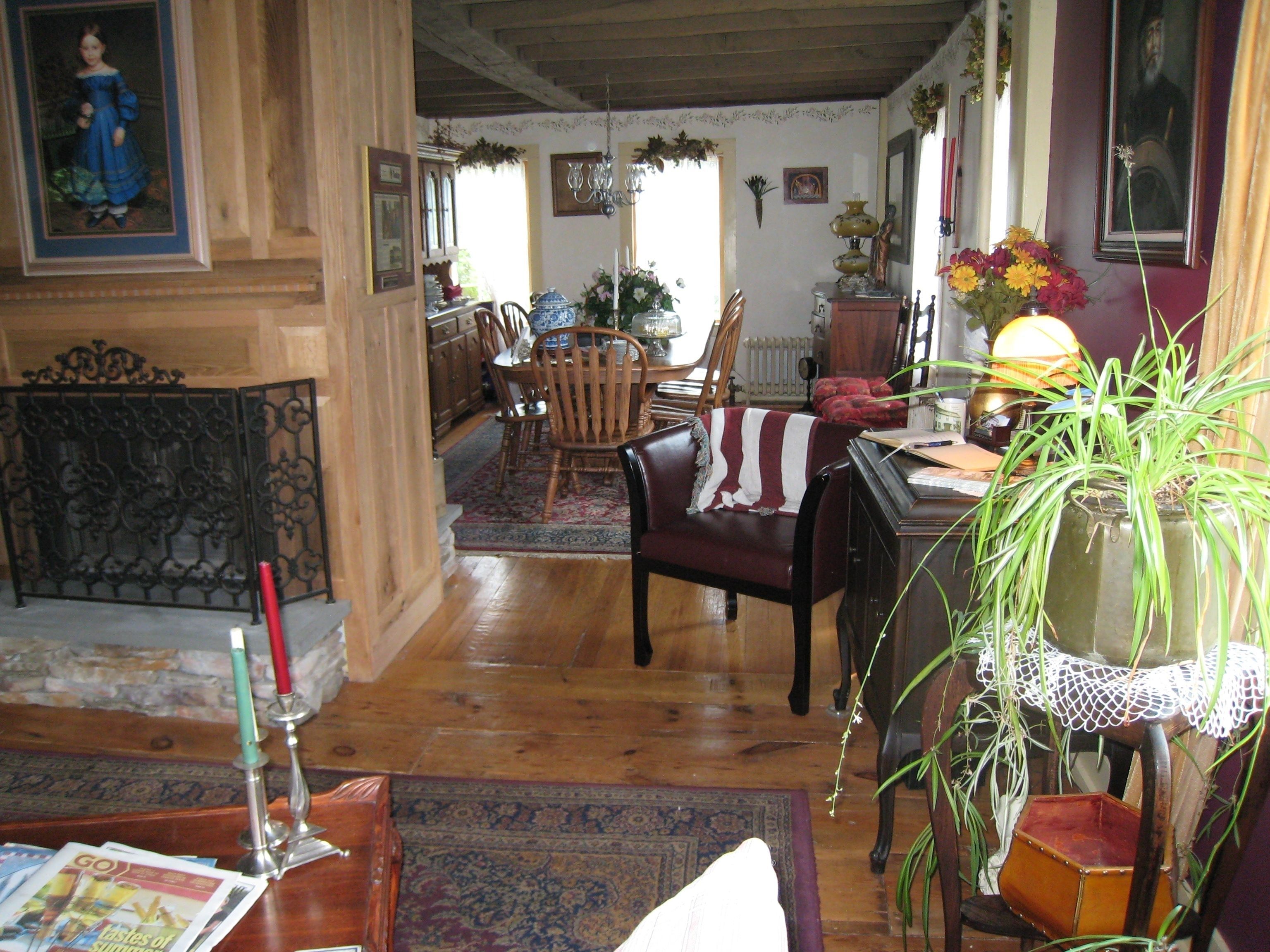 A traditional living room with a fireplace, wooden furniture, and a dining area.