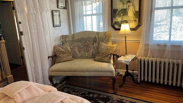 Una habitación acogedora con un sofá antiguo, una manta estampada y una lámpara clásica.