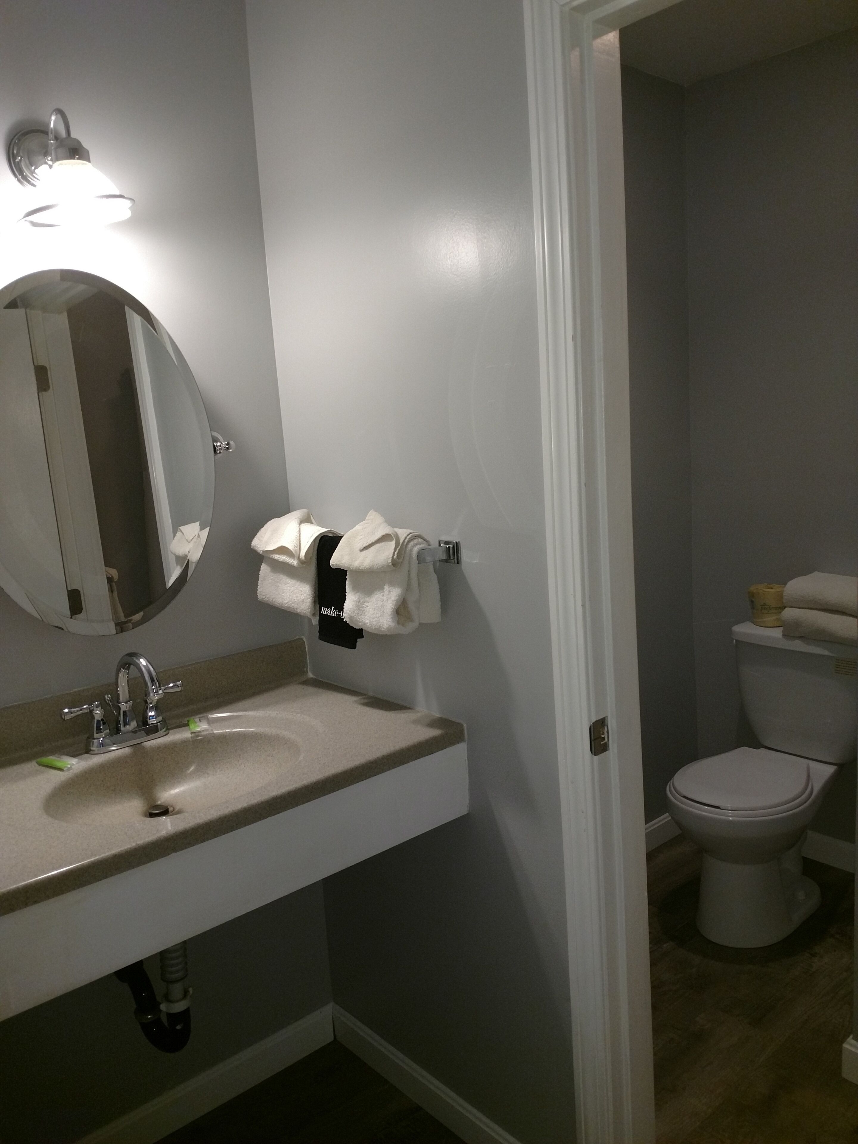 Ein Badezimmer mit Waschbecken, Spiegel und Toilette.