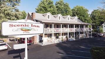 A two-story motel with a balcony on the second floor, a covered front porch, and a sign reading "Scenic Inn of Conway."