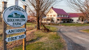 A sign for The Inn at Buck Hollow Farm, indicating it offers antiques and folk art. - The Inn at Buck Hollow Farm (Fairfax)