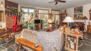 A cozy living room with a fireplace, a television, and a dining area. - The Inn at Buck Hollow Farm (Fairfax)