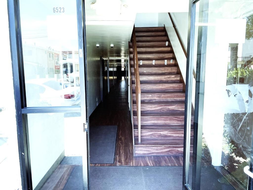 A staircase leading to a hallway with a glass door entrance.