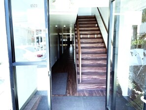 A staircase leading to a hallway with a glass door entrance.