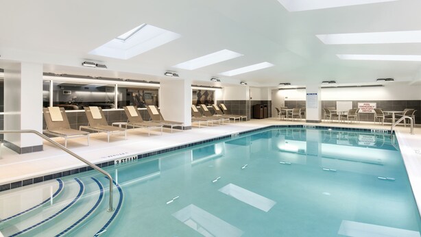 A modern indoor swimming pool with clear water, sunroof lighting, and lounge chairs along the poolside. - The Lowline Hotel, part of JdV by Hyatt Charleston (Charleston)