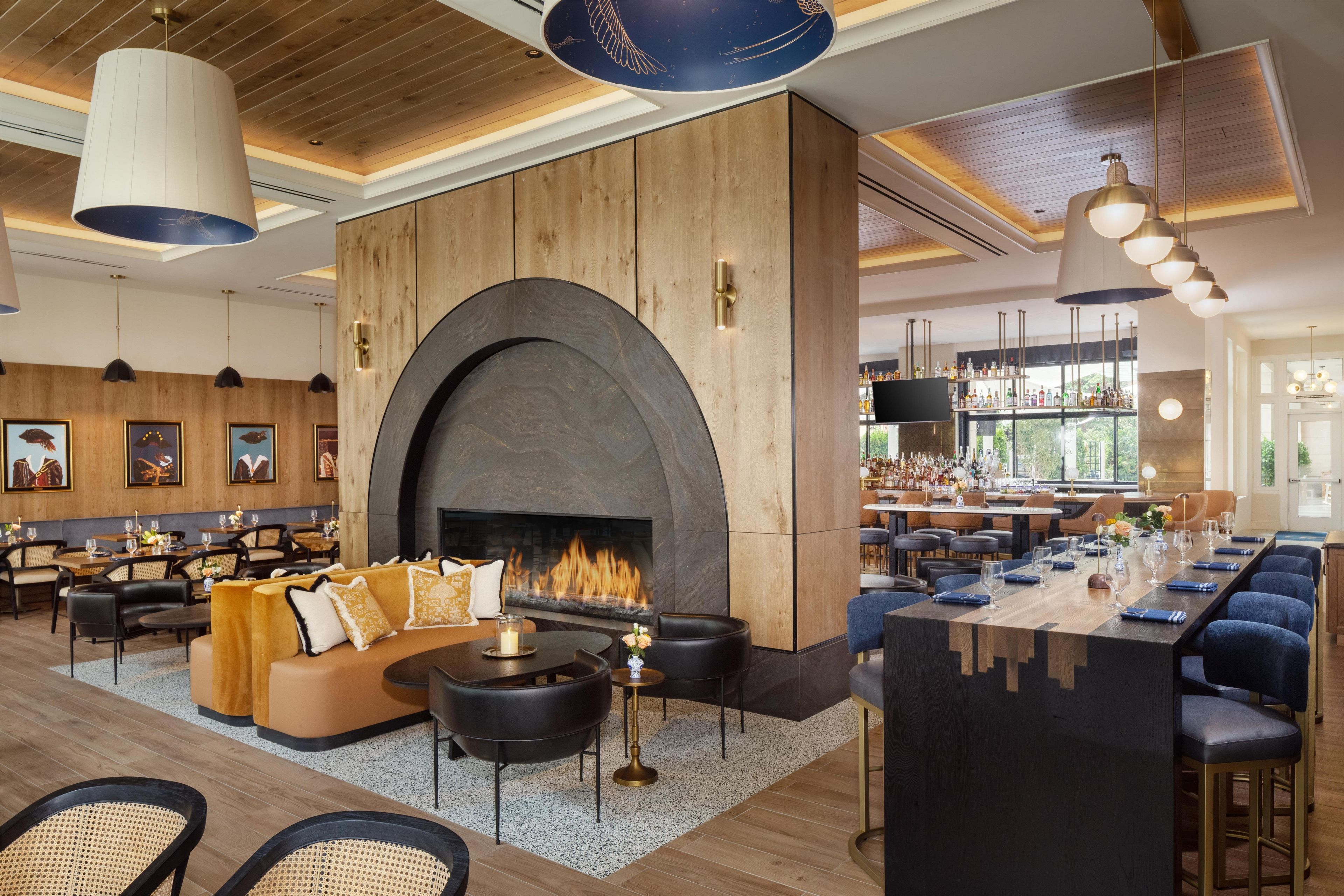 A restaurant with a fireplace, seating, and a bar area.