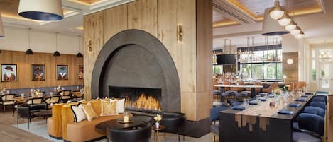 A restaurant with a fireplace, seating, and a bar area.